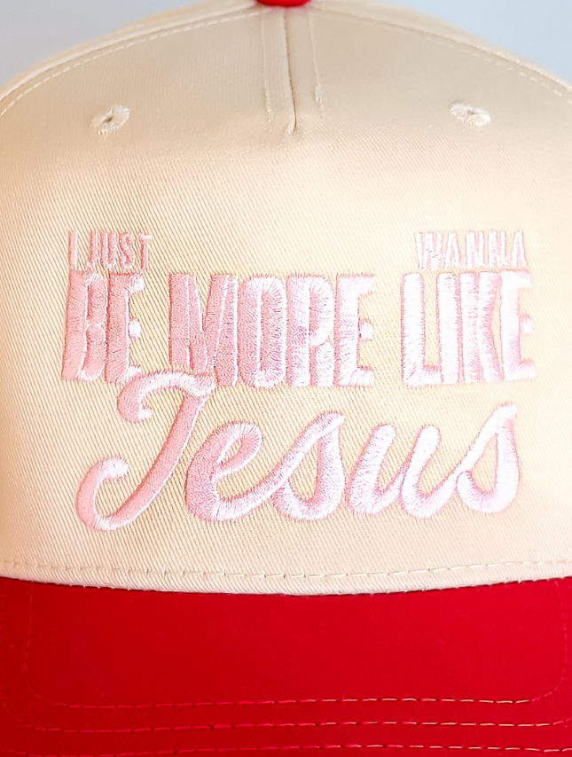 Beige and red trucker hat with embroidered text reading "I just wanna be more like Jesus.