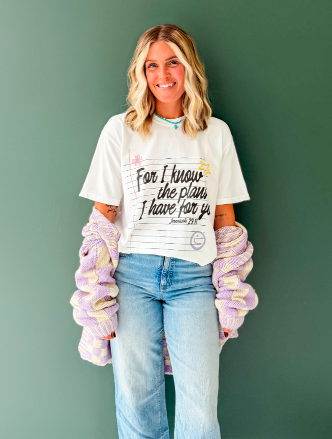 Jeremiah 29:11 tee in white, featuring handwritten text and sun graphic, worn with a purple and cream cardigan.