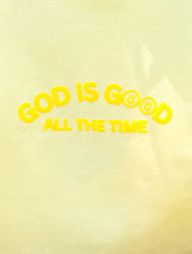 Yellow puff tee featuring the text "God Is Good" and "All The Time" in bright yellow letters.