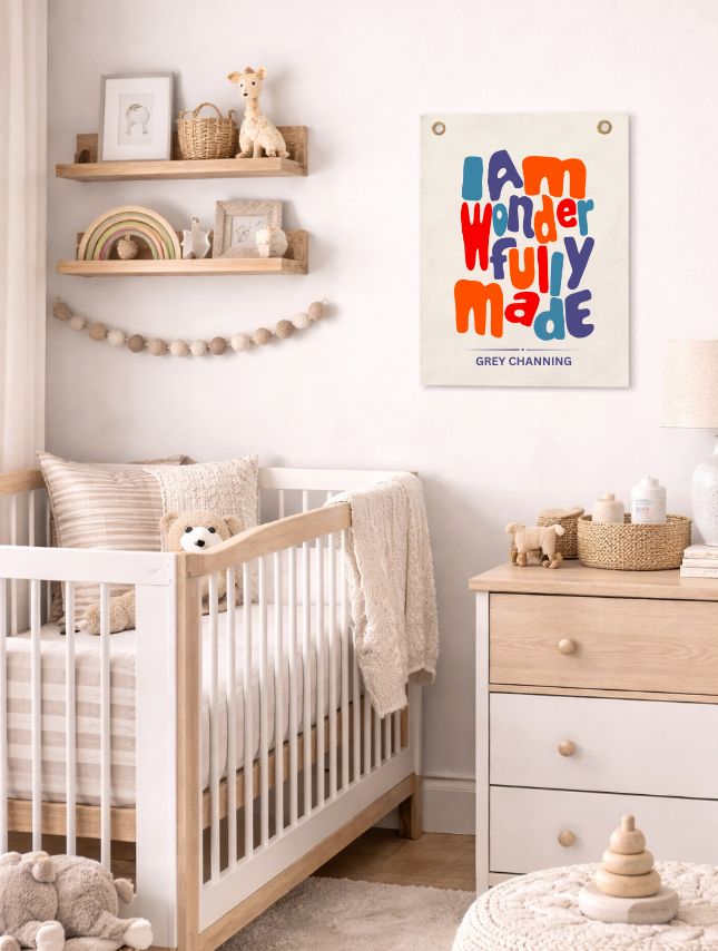 Personalized tapestry with colorful text "I am wonderfully made" displayed in a nursery with a crib and decor.
