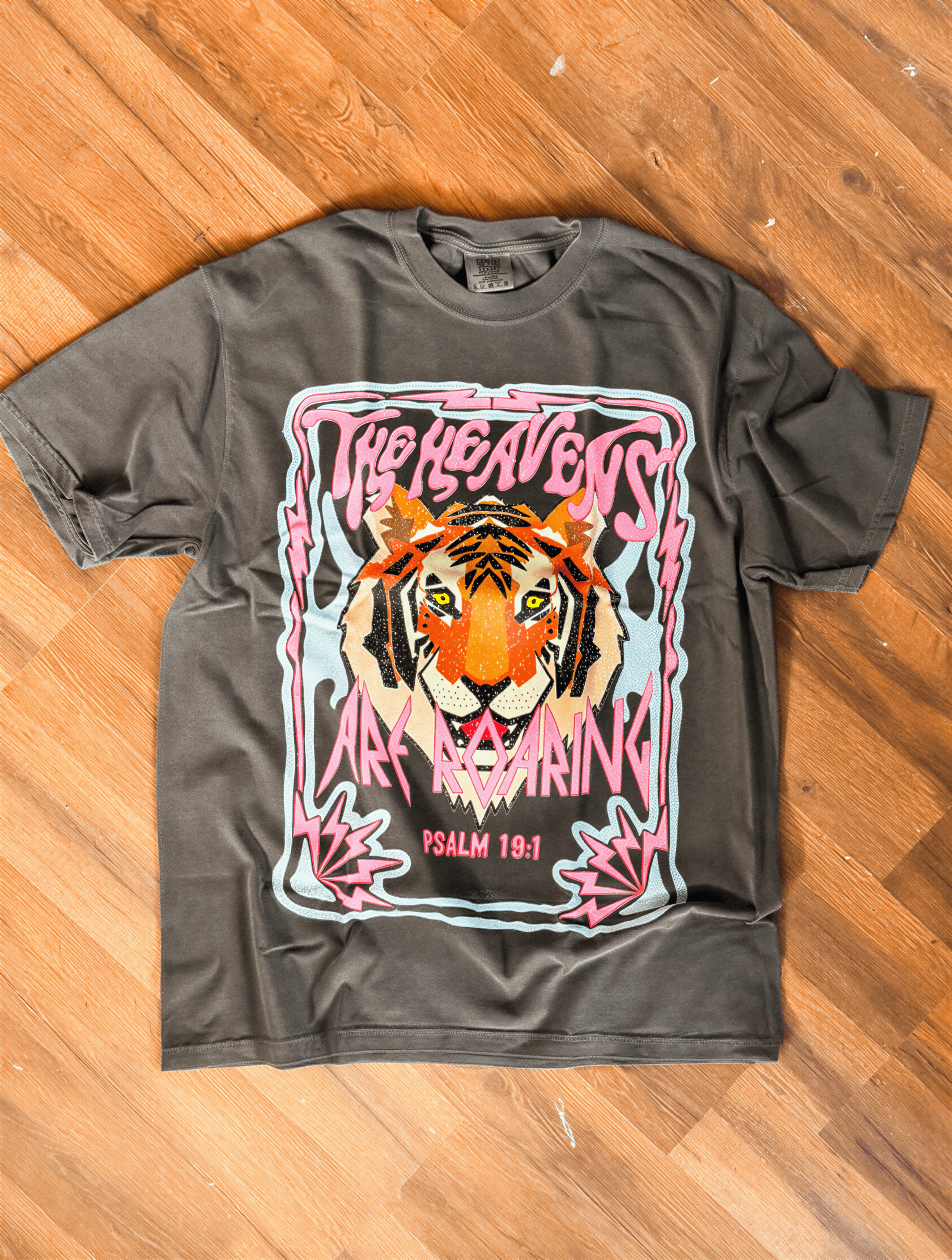 flat lay of the heavens are roaring tee