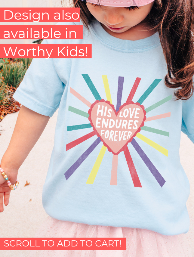 Light blue t-shirt featuring a heart design with the text "His Love Endures Forever" and colorful rays radiating outward.