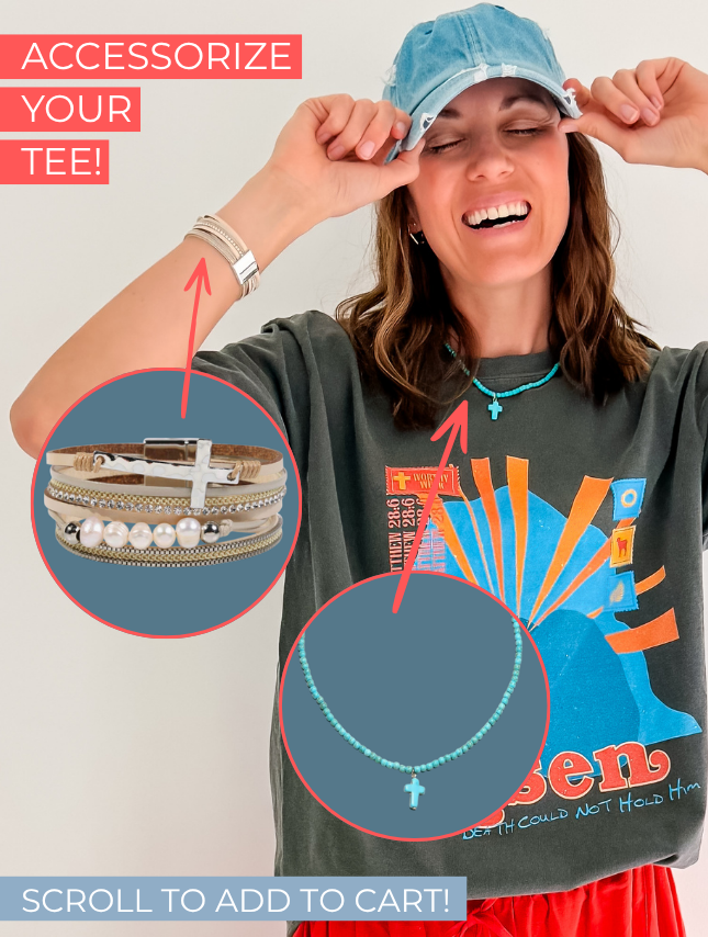 He Is Risen Tee in dark gray, featuring colorful graphic design, worn by a smiling woman with accessories.
