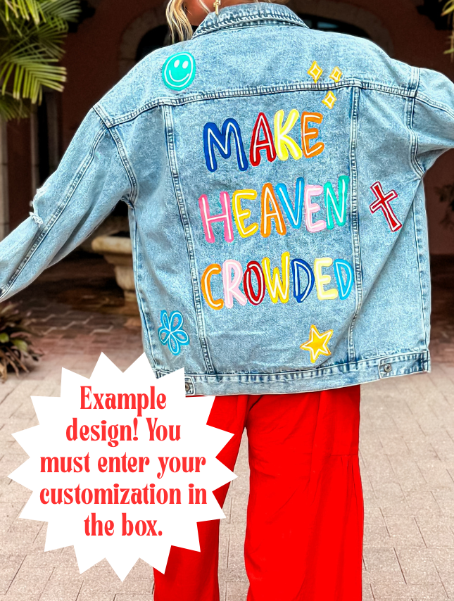 Denim jacket with colorful text "Make Heaven Crowded" and decorative symbols, worn with red pants.