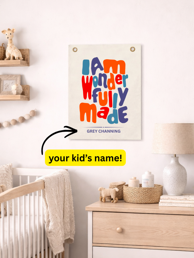 Personalized tapestry with colorful text "I am wonderfully made" and a placeholder for a child's name, displayed in a nurs...