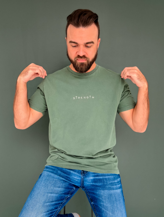 Man wearing a green t-shirt with 'STRENGTH' printed on it against a gray background