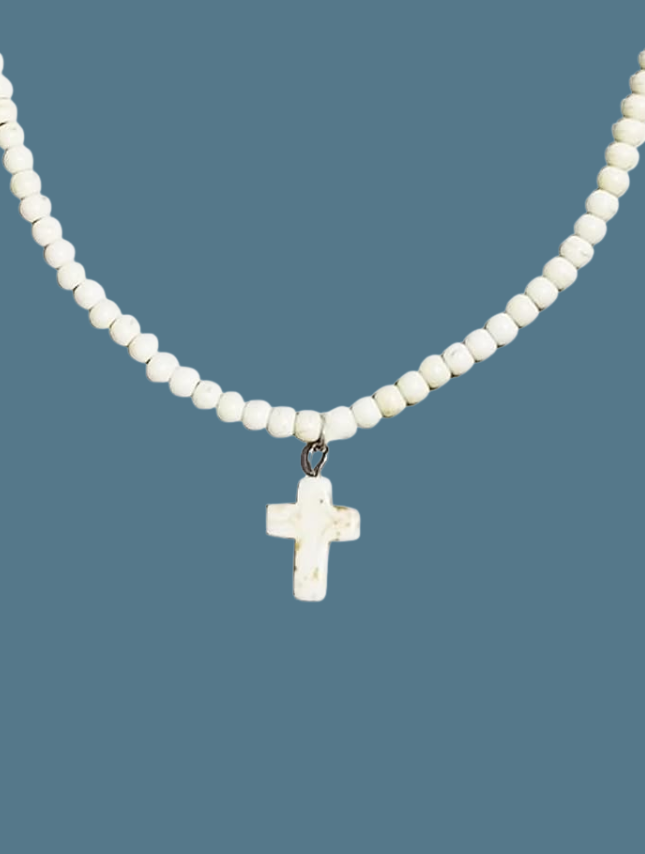 White beaded cross necklace featuring small white beads and a central cross pendant.