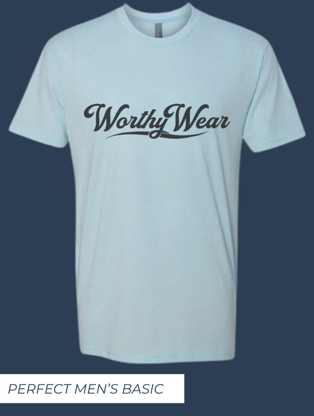 Light blue basic tee featuring "Worthy Wear" logo in black, displayed against a dark background.