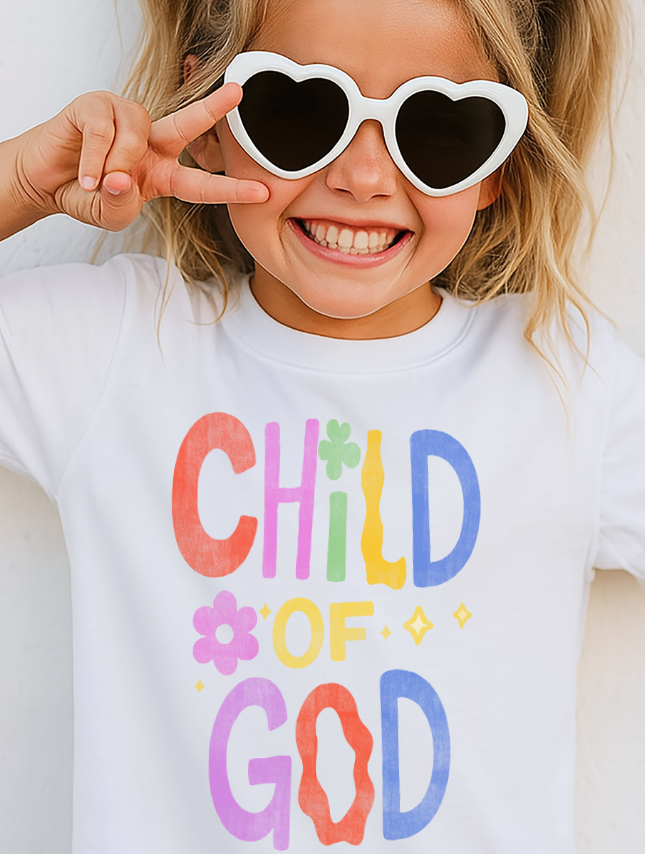 Child wearing heart-shaped sunglasses and a 'Child of God' t-shirt