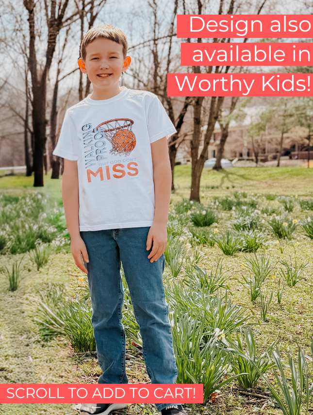 God Don't Miss Tee featuring a basketball graphic, worn by a boy standing in a grassy area with trees in the background.