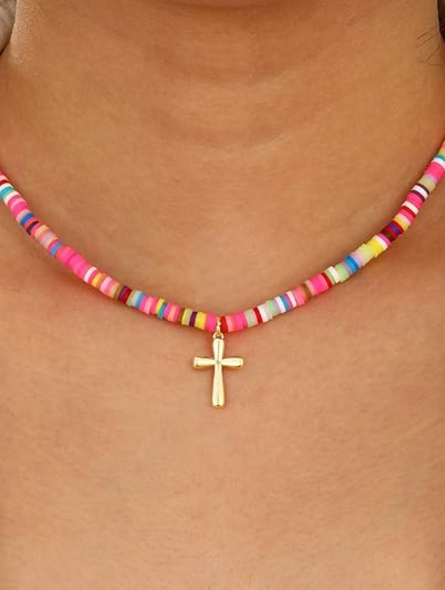 Necklace with colorful beads and a gold cross pendant on a person's neck.