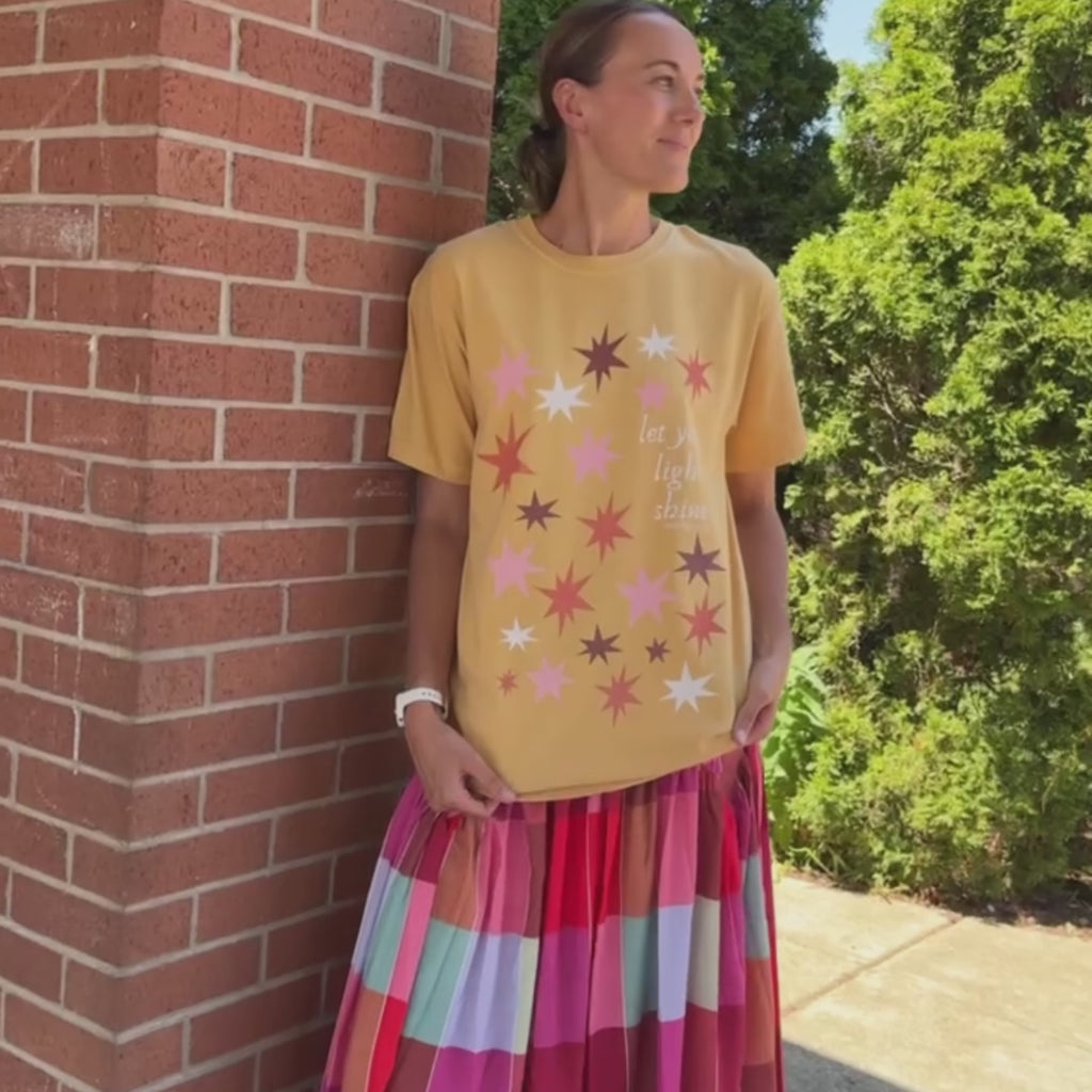 woman wearing let your light shine tee