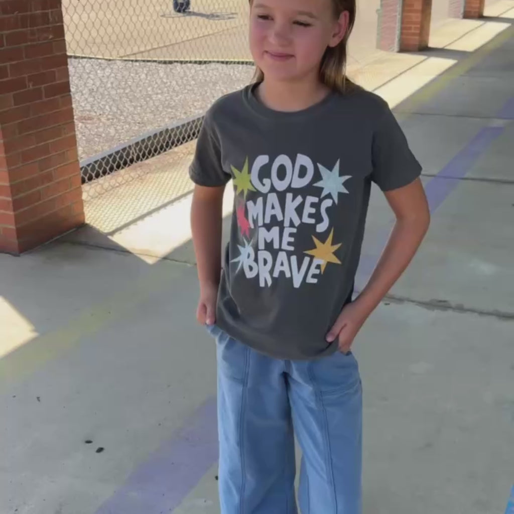 girl wearing god makes me brave tee